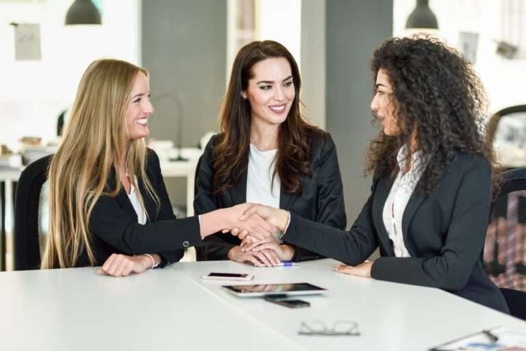 three-businesswomen-shaking-hands-in-a-modern-office